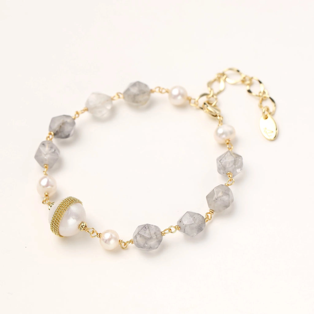 Gold-plated bracelet with white freshwater pearls and translucent grey crystals, featuring mesh-wrapped baroque pearl centerpiece