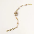 Gold-plated chain bracelet with baroque pearl centerpiece and floral charm, featuring mixed freshwater pearls.