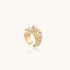 Wide textured gold-plated brass ring with round freshwater pearl centerpiece on neutral background