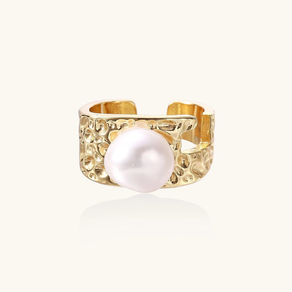 Wide textured gold-plated brass ring with round freshwater pearl centerpiece on neutral background