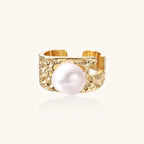 Wide textured gold-plated brass ring with round freshwater pearl centerpiece on neutral background