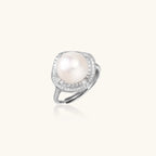 Sterling silver ring with 11mm freshwater pearl surrounded by double diamond halo on white background.