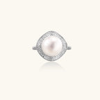Sterling silver ring with 11mm freshwater pearl surrounded by double diamond halo on white background.