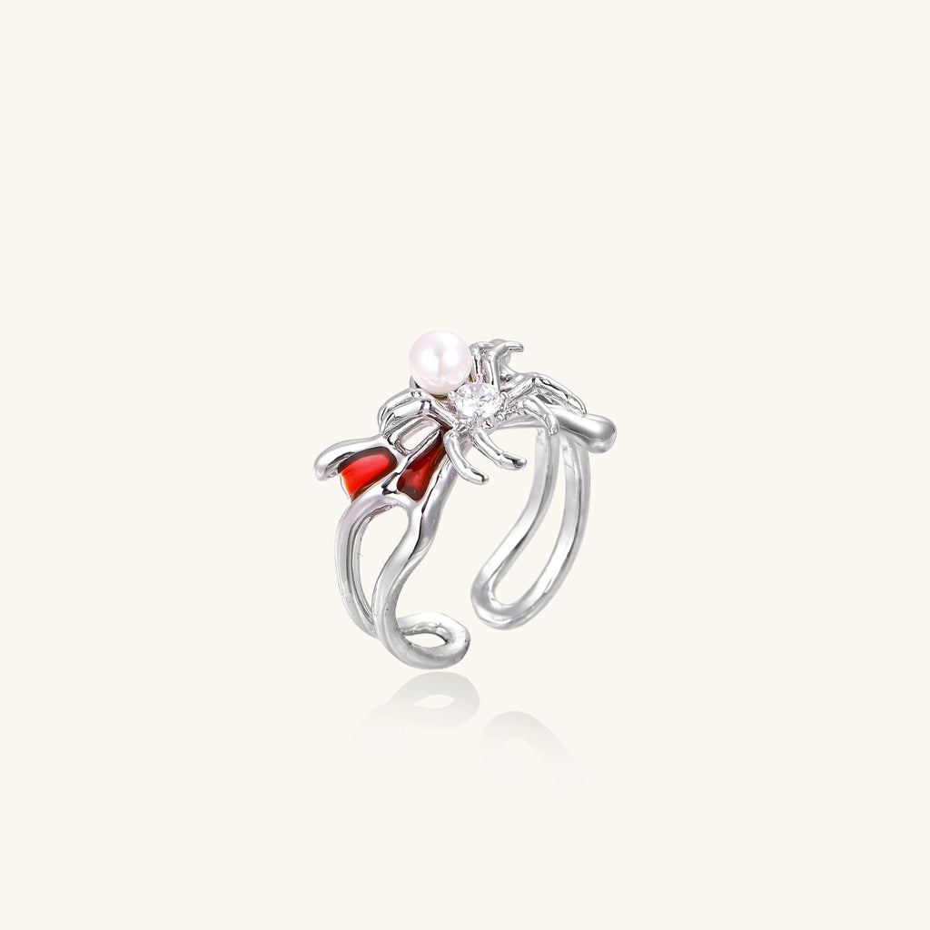 Gold-plated adjustable ring featuring spider design with white pearl, red enamel accents, and central zirconia stone
