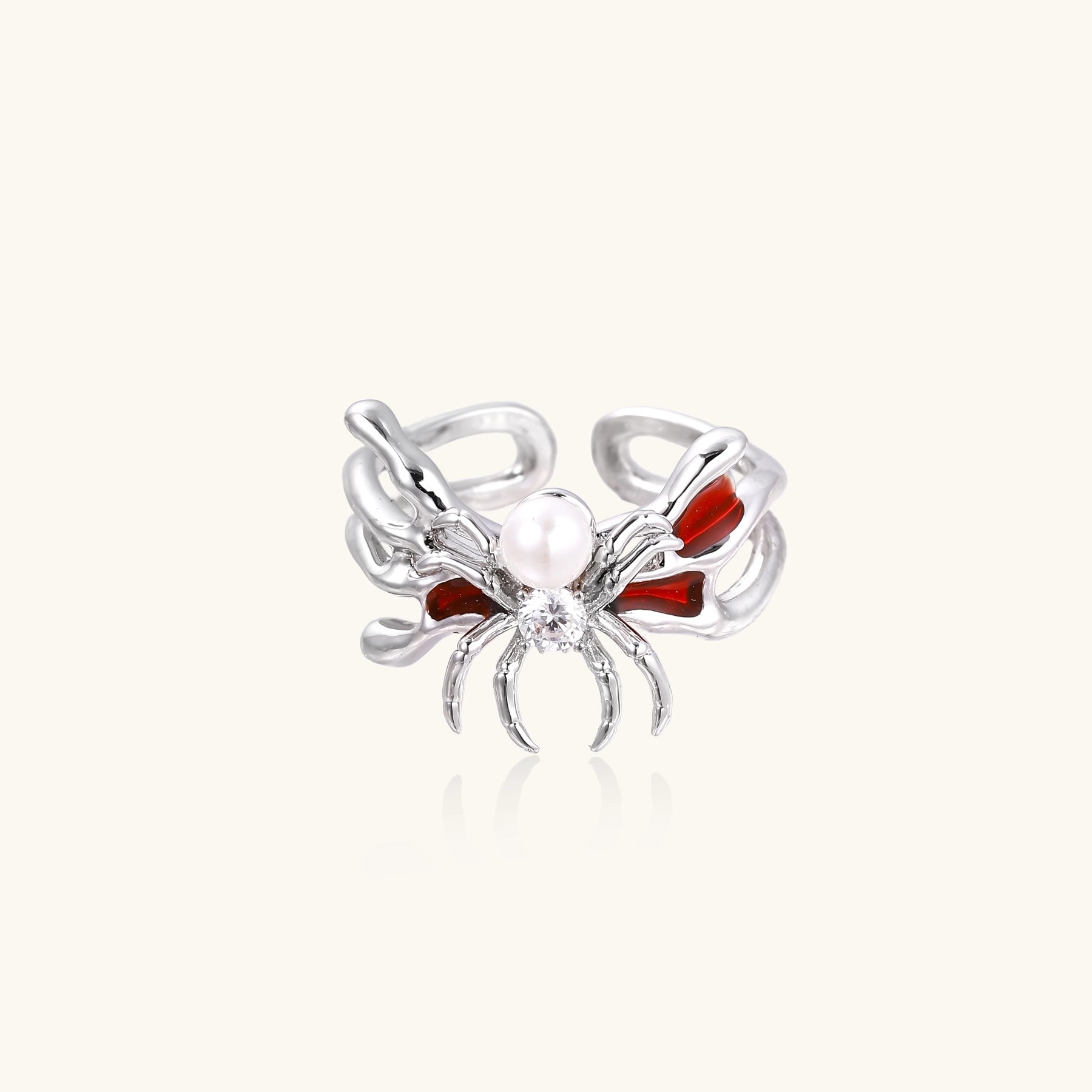 Gold-plated adjustable ring featuring spider design with white pearl, red enamel accents, and central zirconia stone