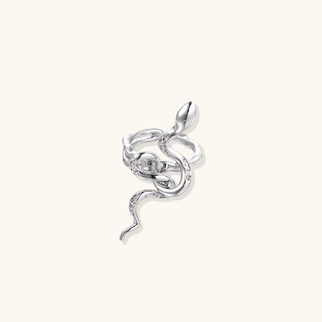 Gold-plated brass snake ring with flowing curves and crystal accents, wrapping around finger in sculptural design
