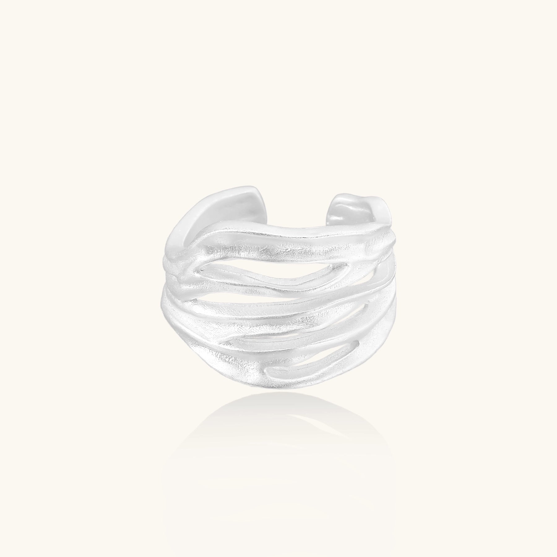 Wide sterling silver ring with flowing wave patterns and adjustable cuff design on white background.