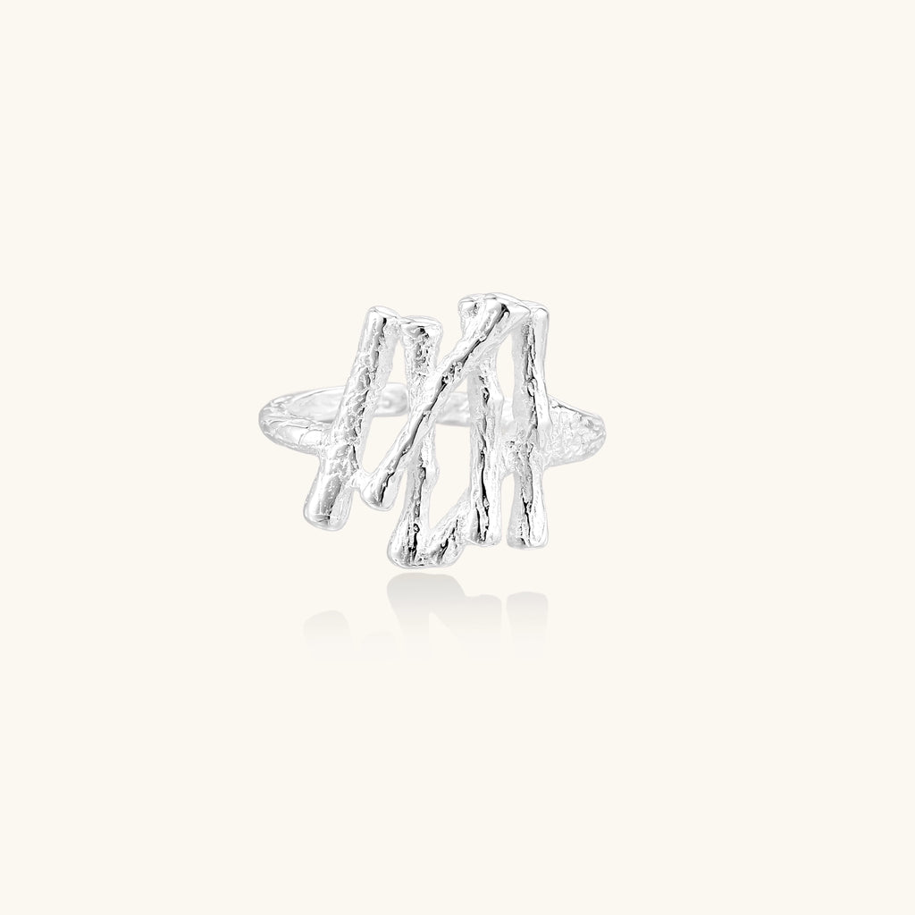 Chunky sterling silver ring with organic sculptural design and flowing abstract forms on white background