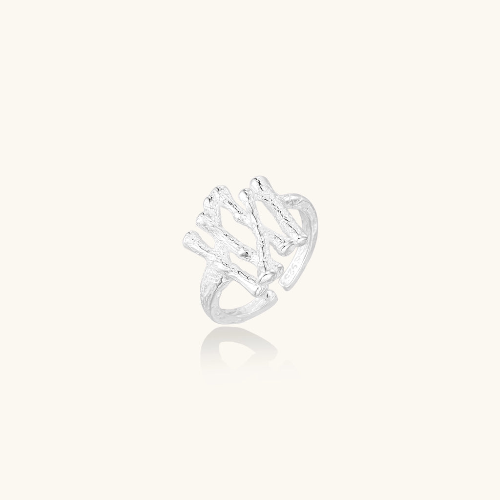 Chunky sterling silver ring with organic sculptural design and flowing abstract forms on white background