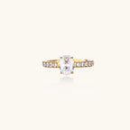 14K gold-plated ring with oval zirconia center stone and pavé band accent stones on white background.